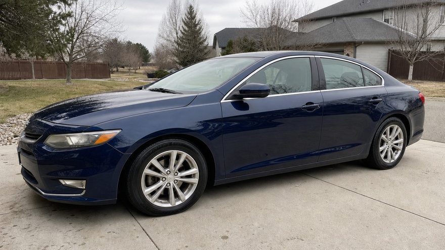 Same sedan after — deep gloss, spotless.